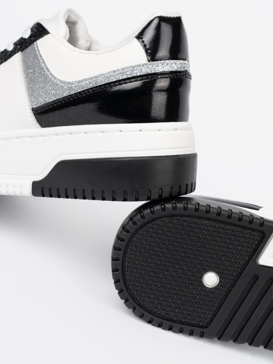 Schwarz-weiße Sneakers mit glänzenden silbernen Details