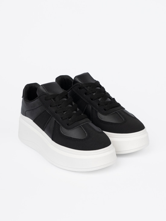 Klassische schwarze Sneakers mit dicker Sohle