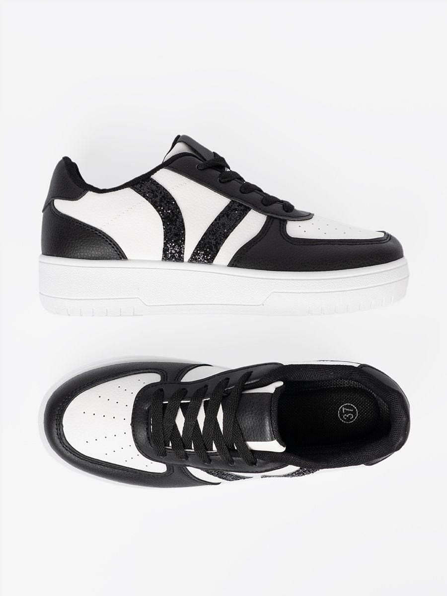 Stylische schwarz-weiße Sneakers mit glitzernden Details
