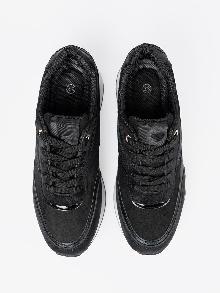 Moderne schwarze Sneakers mit glänzenden Details