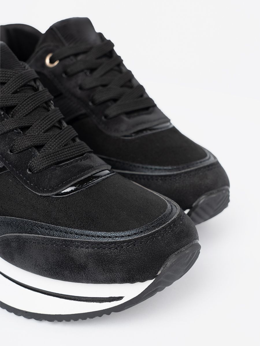 Moderne schwarze Sneakers mit glänzenden Details