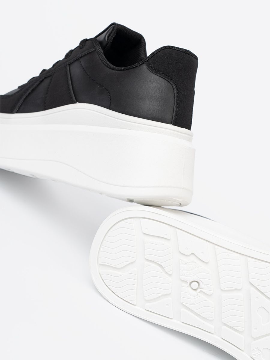 Klassische schwarze Sneakers mit dicker Sohle