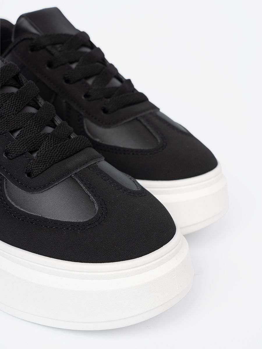Klassische schwarze Sneakers mit dicker Sohle
